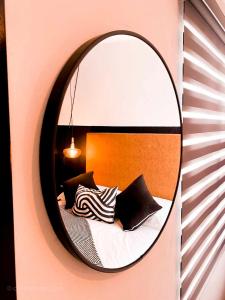 a mirror on a wall with a bed with pillows at Cielito Home in Jesús María