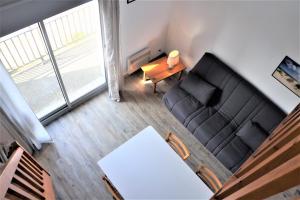 uma sala de estar com um sofá preto e uma mesa em Appartement 3 pièces 5 à 6 personnes - vue mer - à 200 m de la plage - FANTA em Ploemeur