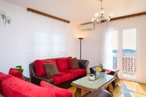 a living room with a red couch and a table at Bellevue Duplex Apartment in Dubrovnik