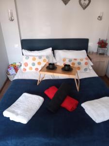 łóżko z niebieskim kocem i stołem na nim w obiekcie Słoneczne studio w mieście Szczawnica