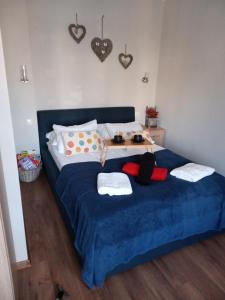 a bedroom with a blue bed with towels on it at Słoneczne studio in Szczawnica