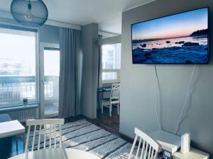 uma sala de estar com uma televisão pendurada numa parede em Tapiola Center Apartment em Espoo