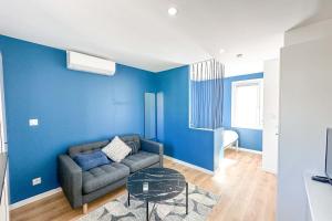 ein Wohnzimmer mit einem Sofa und einer blauen Wand in der Unterkunft Studio neuf aux Réformés à 2 min du metro in Marseille