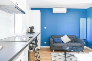 ein Wohnzimmer mit blauen Wänden und einem Sofa in der Unterkunft Studio neuf aux Réformés à 2 min du metro in Marseille
