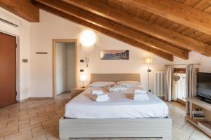 a bedroom with a large bed and a television at La Filanda Apartments by Wonderful Italy - Canapa in Bellagio