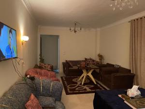 un salon avec des canapés et une télévision à écran plat dans l'établissement Gardenia city cairo, au Caire