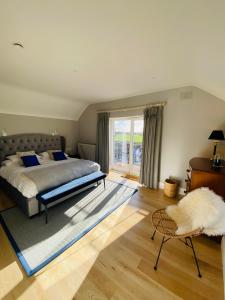 um quarto com uma cama e uma grande janela em The Granary, Luxuriously Restored Barn on a Farm em Thurles