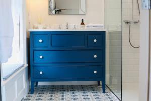 uma cómoda azul na casa de banho com chuveiro em The Granary, Luxuriously Restored Barn on a Farm em Thurles
