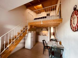 uma cozinha e sala de jantar com uma escada em espiral numa casa em Camping Tonnara em Cala Sapone