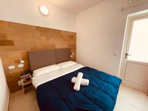 un osito de peluche sentado en una cama en un dormitorio en Camping Tonnara en Cala Sapone