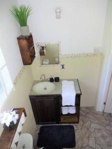 uma casa de banho com um lavatório e um espelho em St. George's Holiday Studio Vacation of a lifetime em Fontenoy