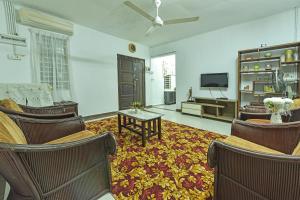 a living room with chairs and a flat screen tv at OYO HOME 90692 Tok Babah Village Homestay in Kampong Sungai Mati