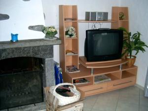 sala de estar con TV y chimenea en Casa Franci, en Ascona