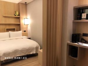 Rúm í herbergi á 菓菓輕旅