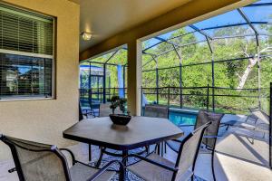 a dining room with a table and chairs on a balcony at Paradise Palms Esate - Paradise Palms Resort in Kissimmee