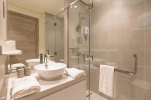 a bathroom with a sink and a glass shower at Revelton Apartment Studio One in Dubai