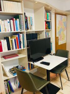 un ordenador sentado en un escritorio en una biblioteca en Schöne ruhige Wohnung (42qm) in Messenähe!, en Düsseldorf