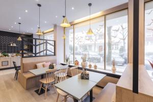 een restaurant met tafels, stoelen en ramen bij Yggotel Spurv in Berlijn