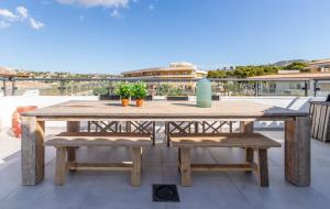 una mesa de madera y bancos en un patio en Penthouse Casamora, en Moraira