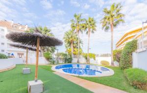 una piscina con sombrilla en un patio con palmeras en Penthouse Casamora, en Moraira