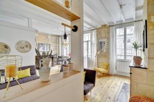 a living room with a couch and a table at Le Rétro - Bail Mobilité - cœur des Chartrons in Bordeaux