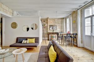 a living room with a couch and a table at Le Rétro - Bail Mobilité - cœur des Chartrons in Bordeaux