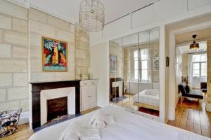 a bedroom with a fireplace and a bed at Le Rétro - Bail Mobilité - cœur des Chartrons in Bordeaux