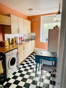 una cocina con suelo a cuadros en blanco y negro en 2 Bedroom flat on Tottenham High Rd. en Londres