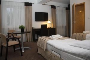 Pokój hotelowy z 2 łóżkami i biurkiem w obiekcie Kuklówka Conference w mieście Radziejowice