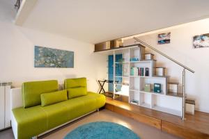 a living room with a green couch and stairs at [DUOMO WALKING DISTANCE] Central Loft in Milan