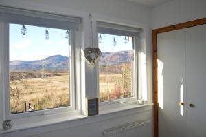 a room with two windows with a heart ornament at Clunebeg Retreat in Spean Bridge