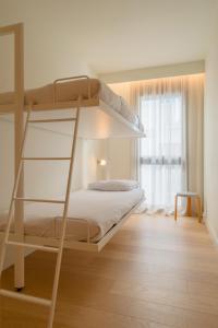 1 dormitorio con litera y escalera en Jardinets De Gràcia by The 5ve Soul, en Barcelona