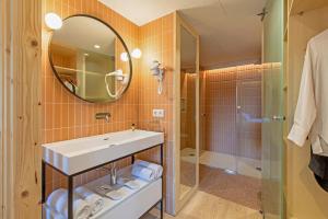 a bathroom with a sink and a mirror and a shower at Jardinets De Gràcia by The 5ve Soul in Barcelona