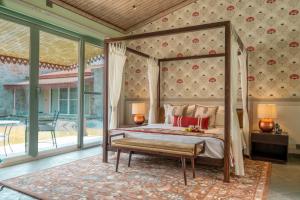 a bedroom with a canopy bed and a large window at Brij Bageecha Jaipur - Private Villas with Plunge Pools in Jaipur