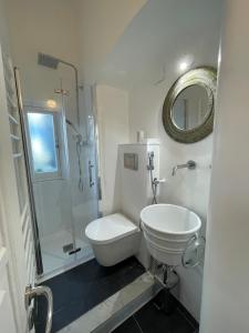 ein weißes Bad mit einem WC und einer Dusche in der Unterkunft La Mansarda dei poeti La Spezia Cinque Terre in La Spezia