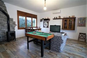 ein Wohnzimmer mit einem Billardtisch und einem TV in der Unterkunft Hauzify I Ca la Nena Morena in Villalba Saserra