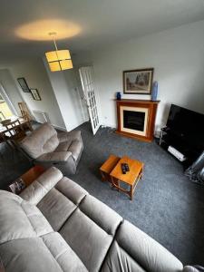 a living room with a couch and a fireplace at Walk to Everything in Crail - Land Sea Cottage in Crail