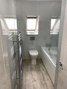 a bathroom with a toilet and a tub and a sink at Walk to Everything in Crail - Land Sea Cottage in Crail +5 photos