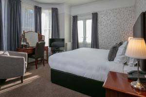 a hotel room with a bed and a desk and a chair at Best Western Annesley House Hotel in Norwich