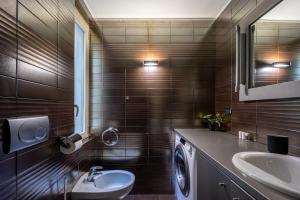 a bathroom with a sink and a washing machine at [Duomo-Montenapoleone] Elegant and Central Suite in Milan