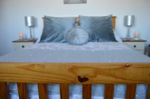 a bed with a wooden frame with a pillow on it at Clunebeg Retreat in Spean Bridge