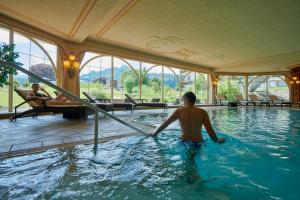 een man in een zwembad in een hotel bij Chalet Alpenstern in Oberstdorf