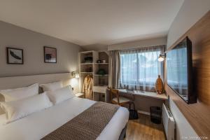 1 dormitorio con cama, escritorio y ventana en Les Hauts de Kerano, en Paimpol