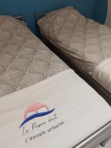 Una cama con un cartel en el costado. en Le Pepin Dort, en Pepinster