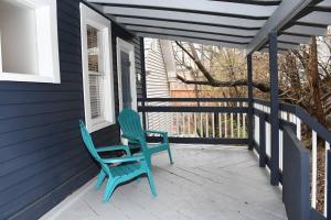 dos sillas sentadas en el porche delantero de una casa azul en Apt - Columbia Tusculum - Patio(2), en Cincinnati