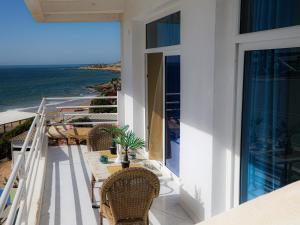 a balcony with a table and chairs and the ocean at Locals Taghazout surfcamp in Taghazout