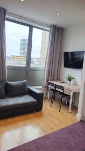 een woonkamer met een bank en een tafel bij Cosy Entire Apartment in WhiteChapel/Commercial Rd in Londen