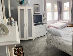 a bedroom with a bed and a tv on a dresser at Turret Corner, Colwyn Bay, 5min walk to sandy beach in Conwy