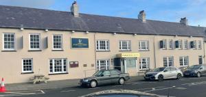 um edifício com carros estacionados em frente em The Portaferry Hotel em Portaferry