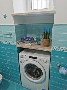 eine Waschmaschine im Bad mit blauen Fliesen in der Unterkunft Casa Carola in Positano